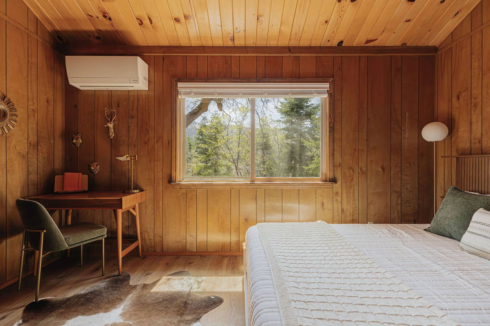 King bedroom with desk and forest window views