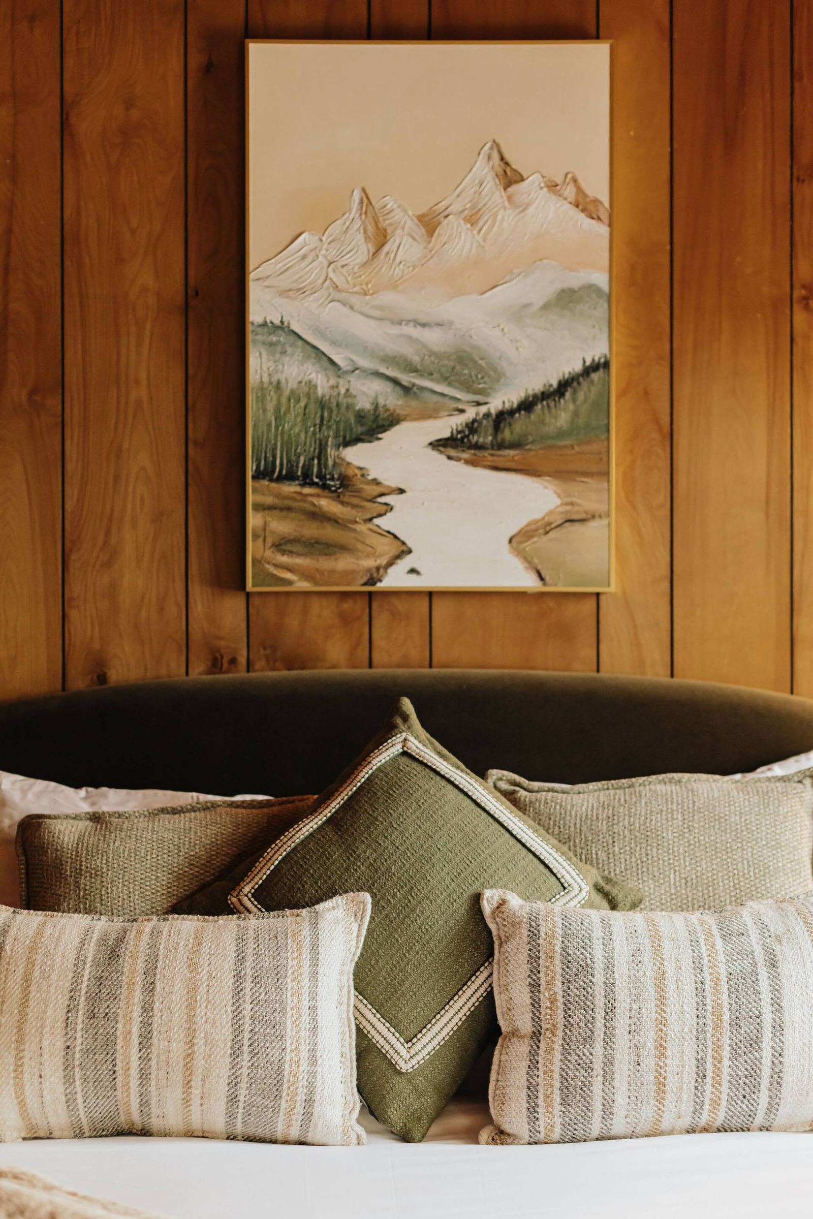 Queen bed with striped lumbar pillow and mountain art