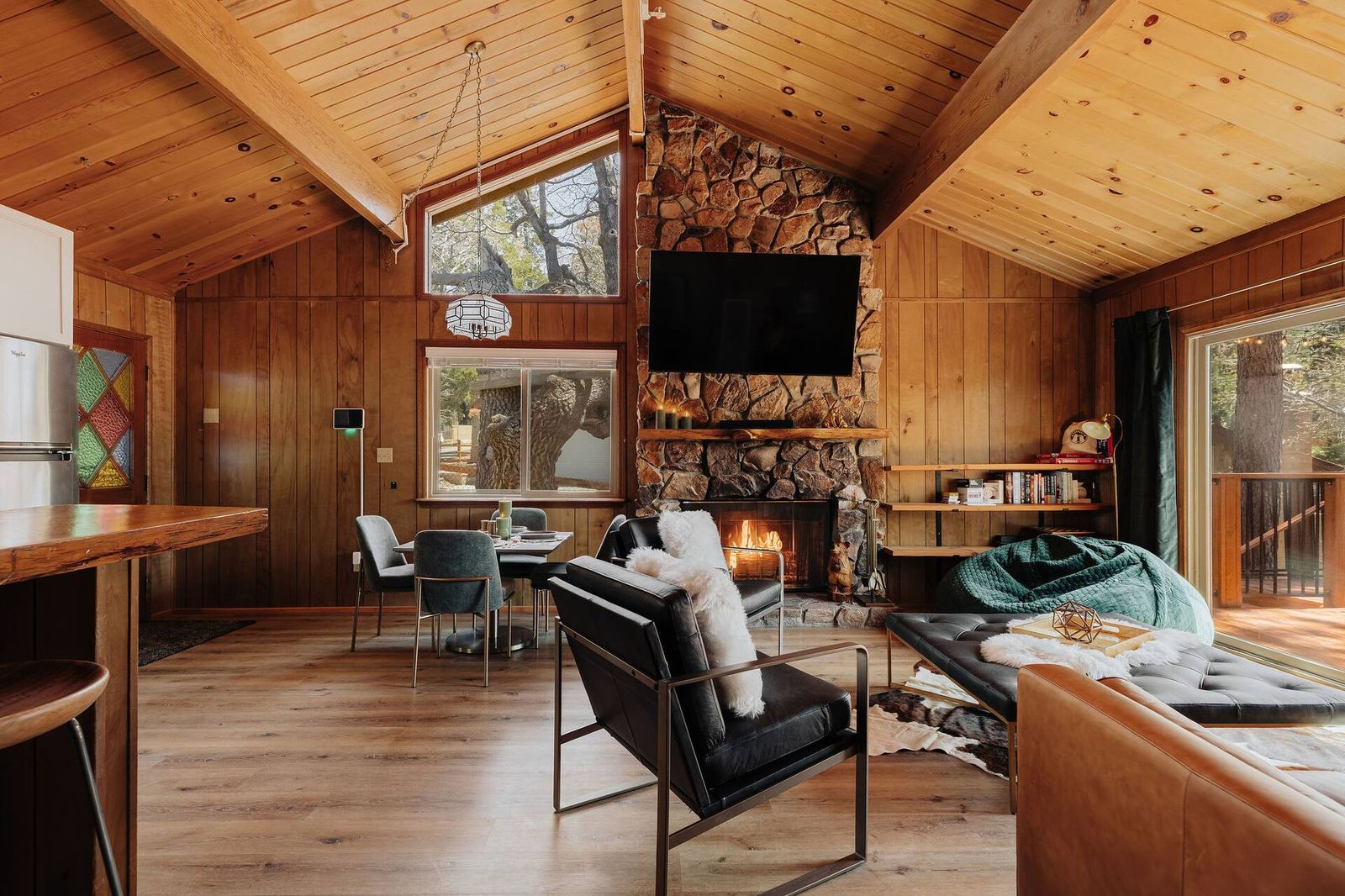 Living room with high ceilings, midcentury furniture, and a flat screen above the hearth